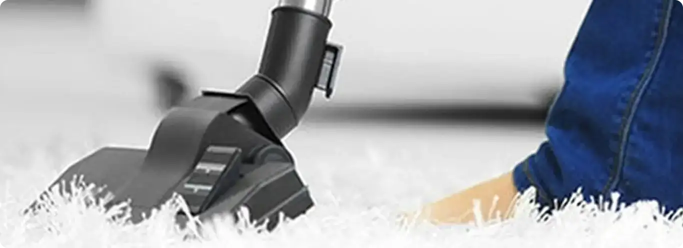 Close-up of a professional vacuuming a white carpet in Goodlettsville.